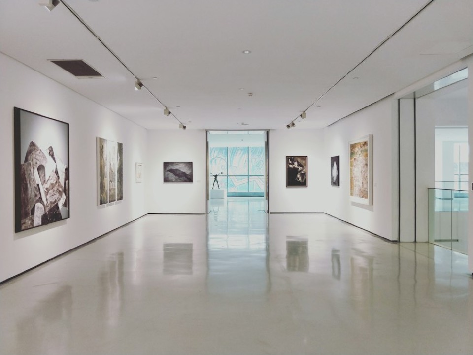 A white-walled gallery with works hung on both sides