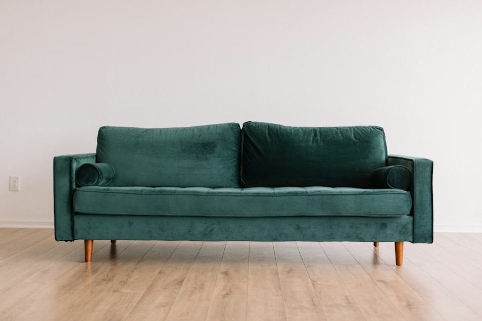 A green velvet sofa on a showroom floor